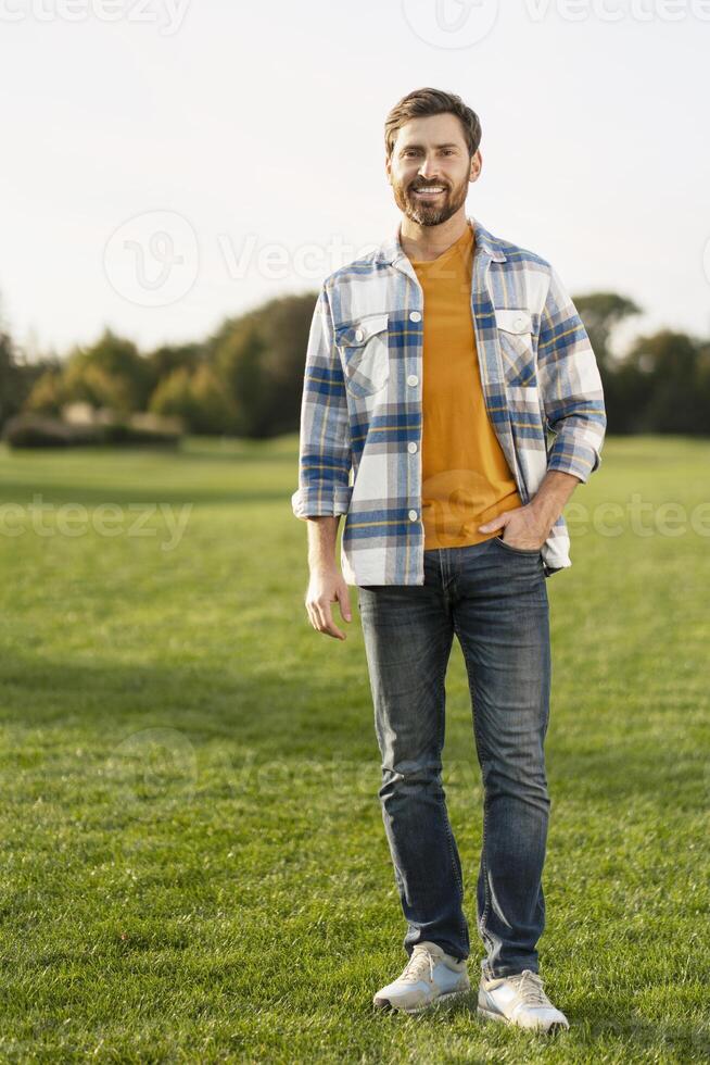 Handsome man smiling and standing in a field photo