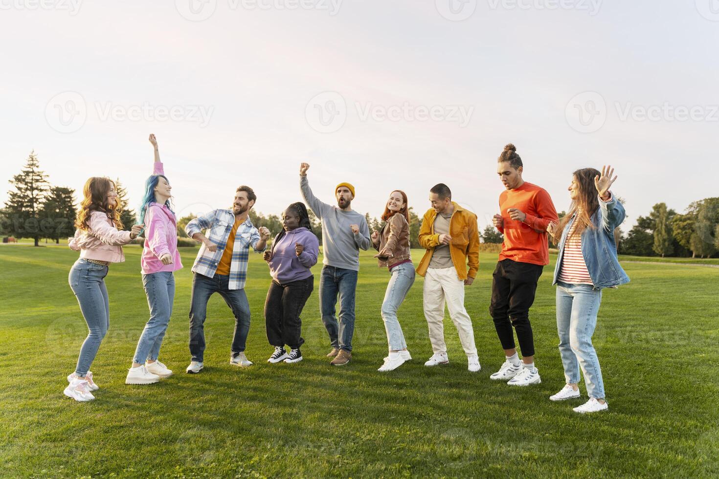Group of friends dancing together in the park photo