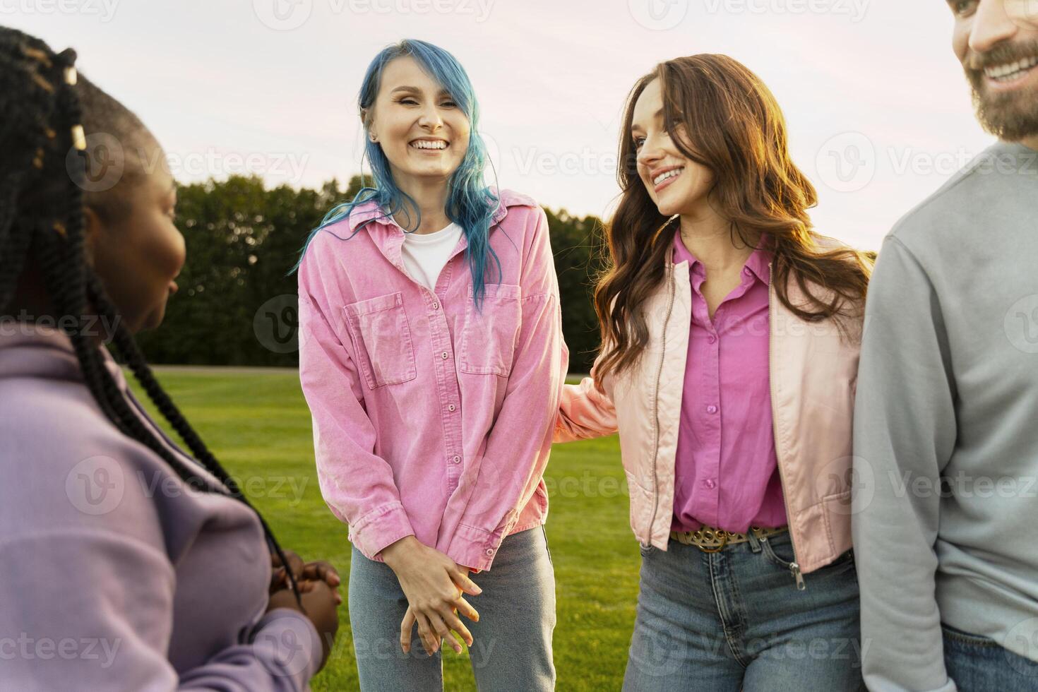 Group of friends smiling and having fun together in a park photo