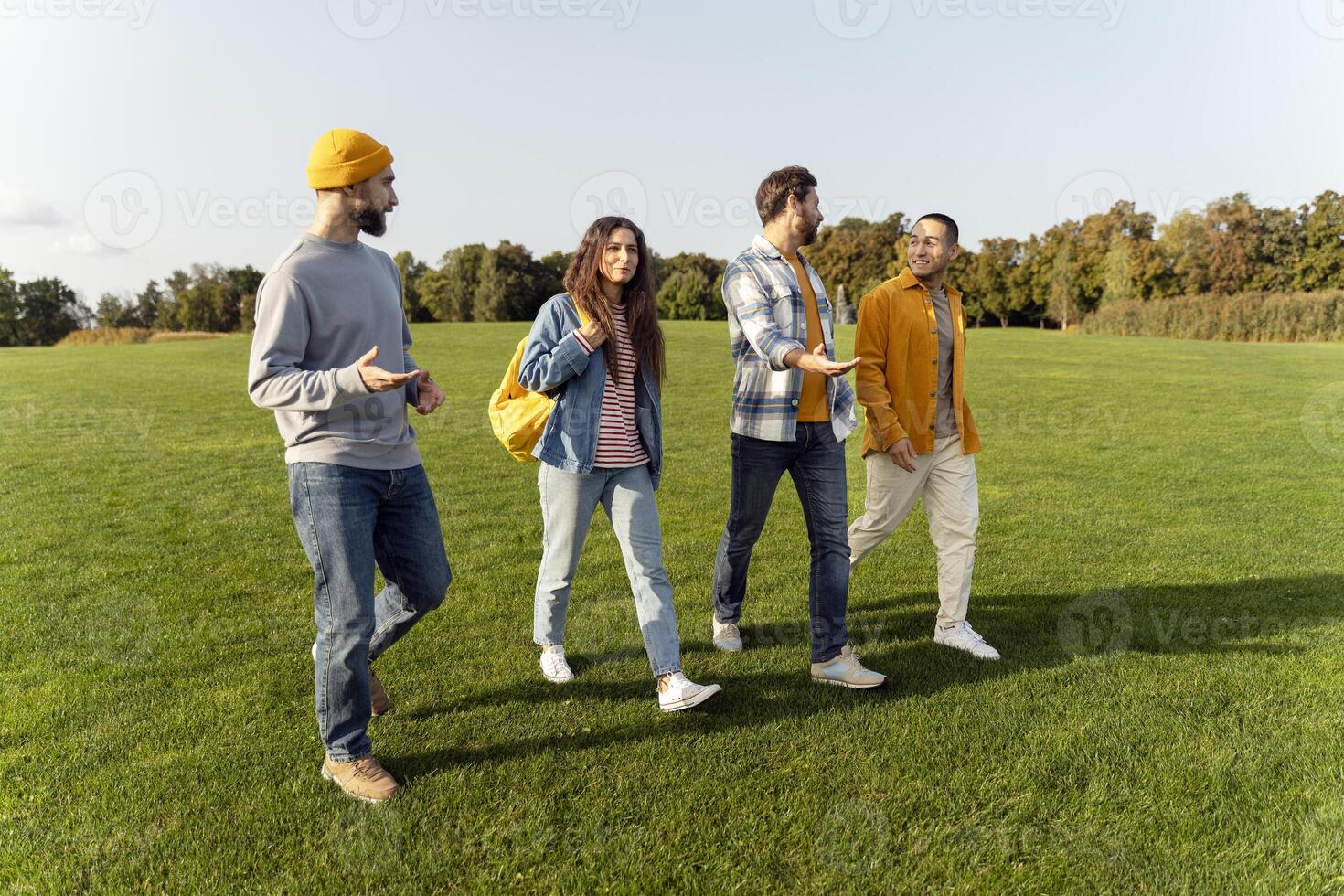Four friends enjoying a lively conversation while walking in the park photo