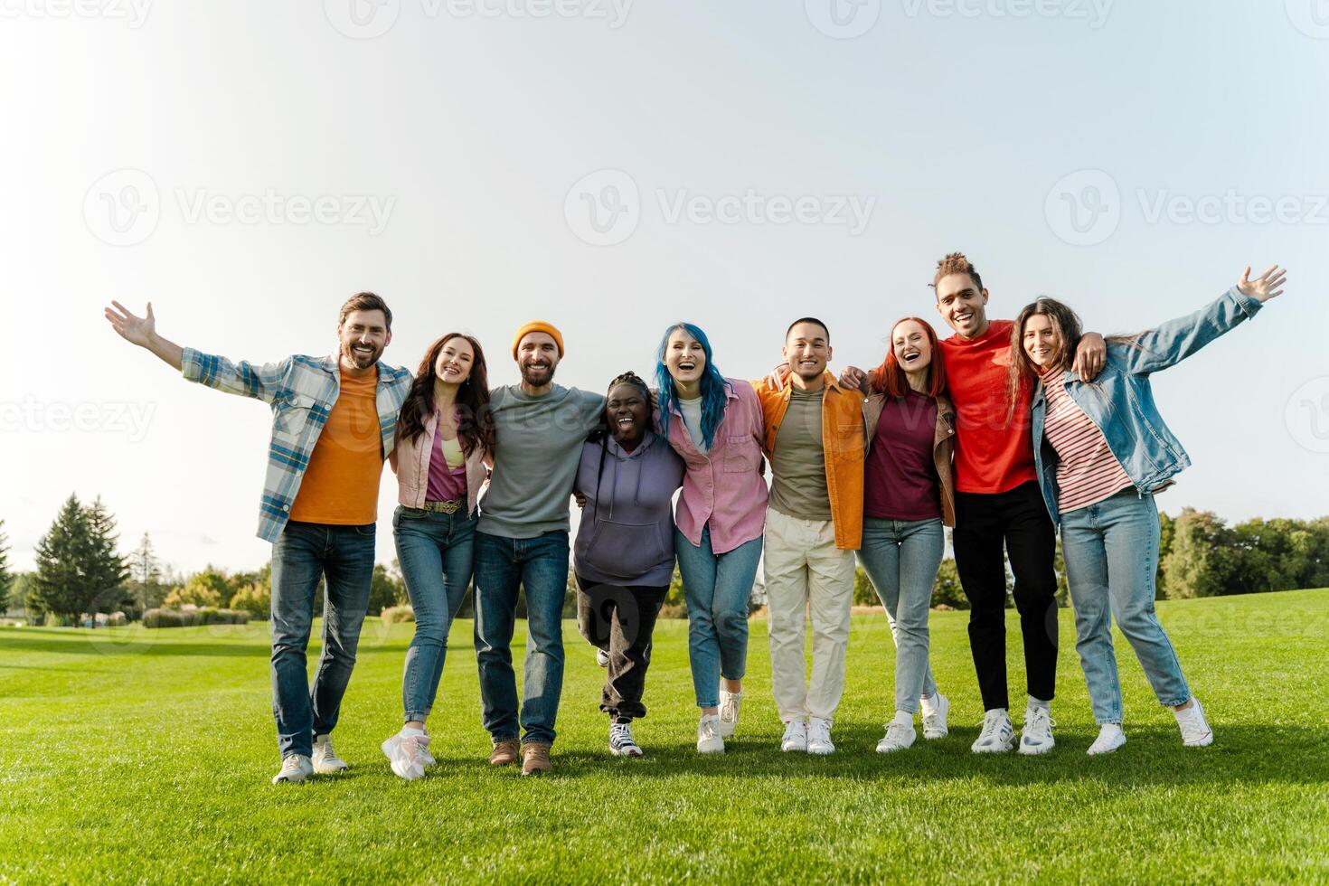 Group of diverse people smiling and having fun together in park photo