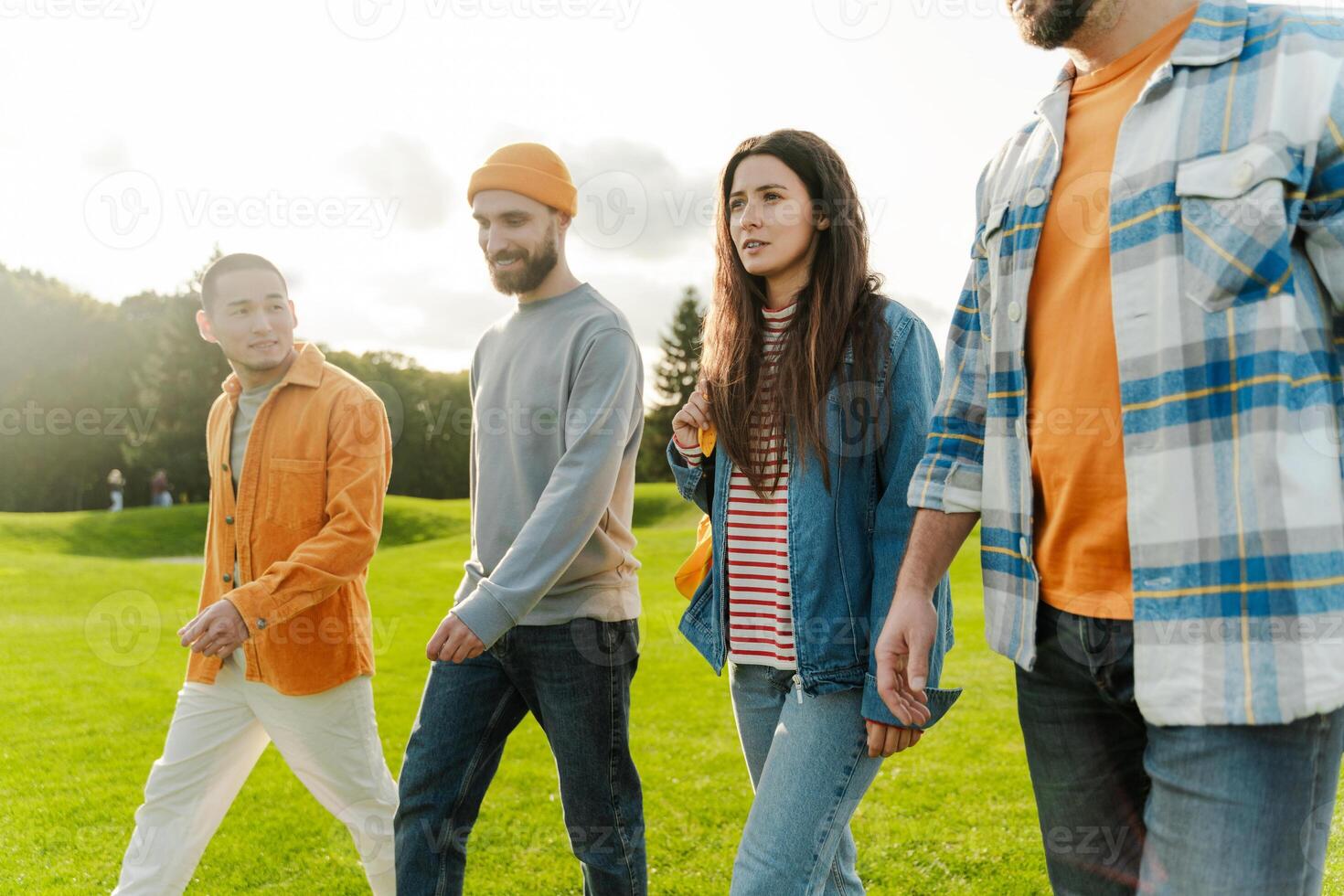 Group of friends walking and talking together in park photo