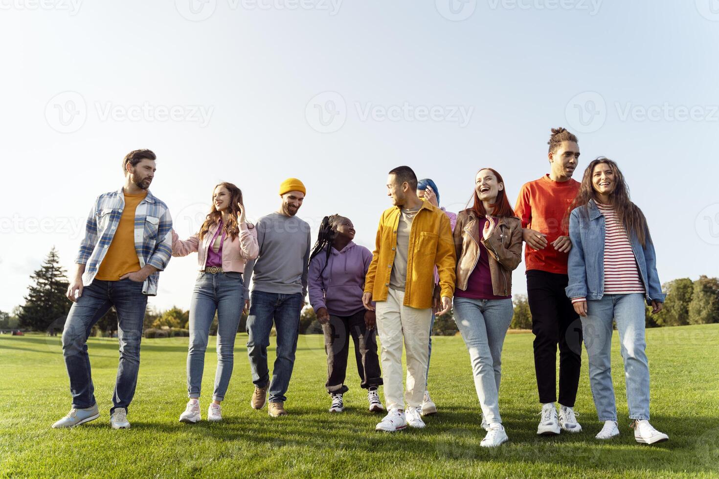 Group of friends walking and talking together in park photo