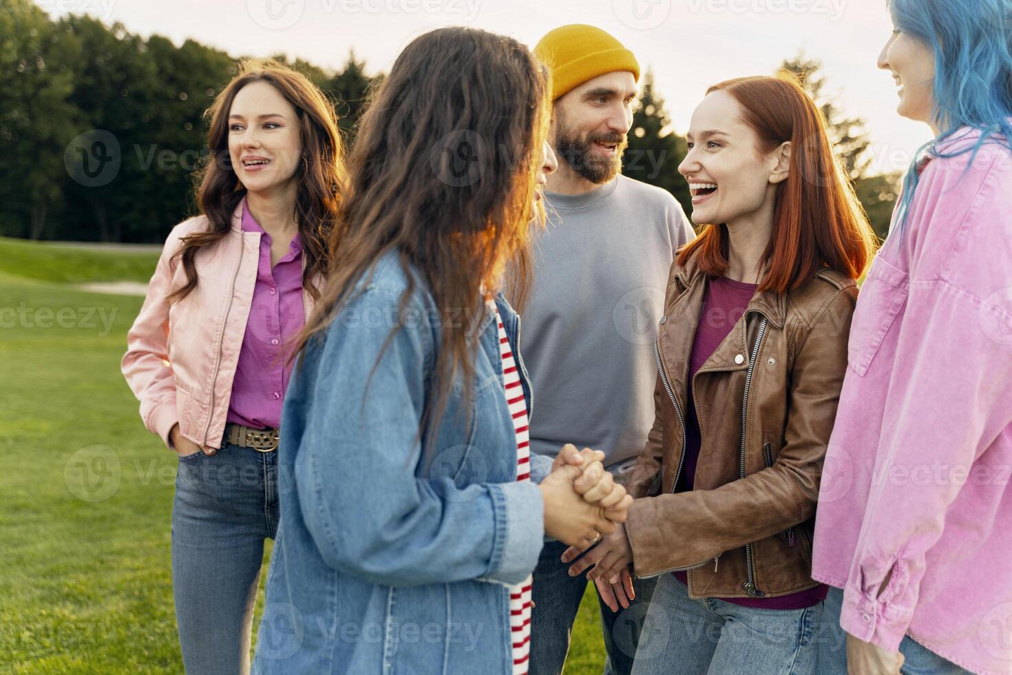 Group of five friends enjoying a sunny day in the park photo