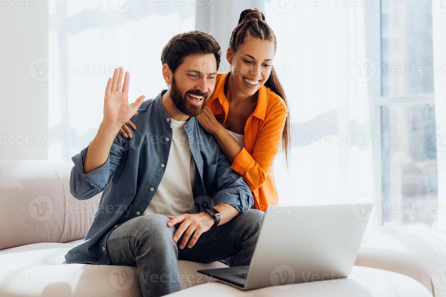 Portrait of happy, smiling Hispanic couple using laptop, waving hand having call photo