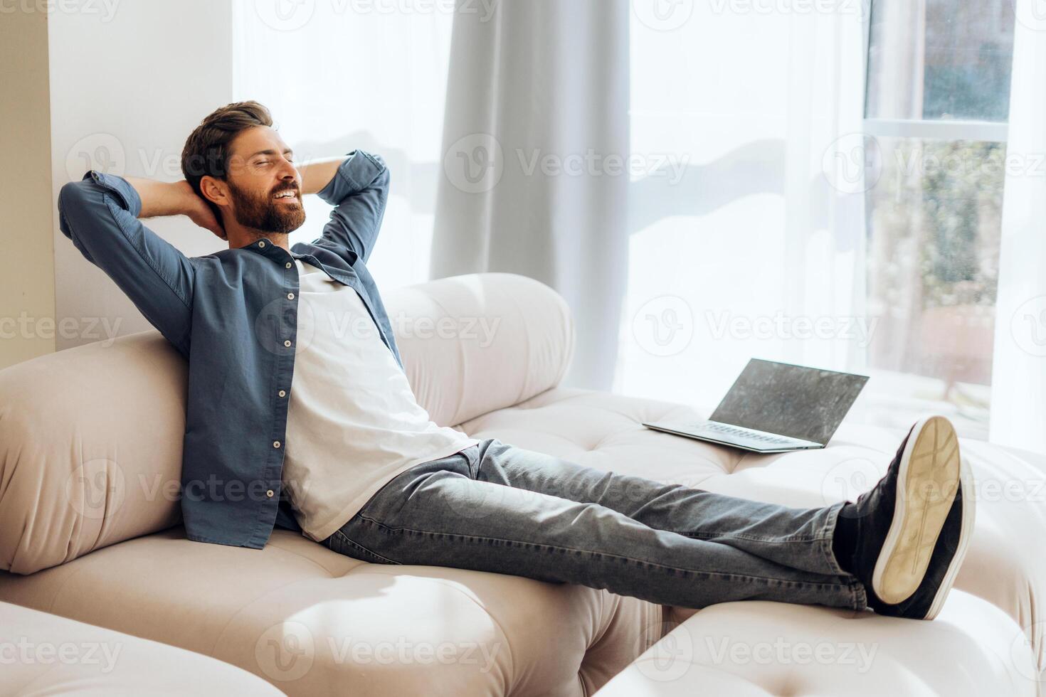 Smiling, happy Hispanic woman lying on comfortable sofa at home, relaxing after work at home photo