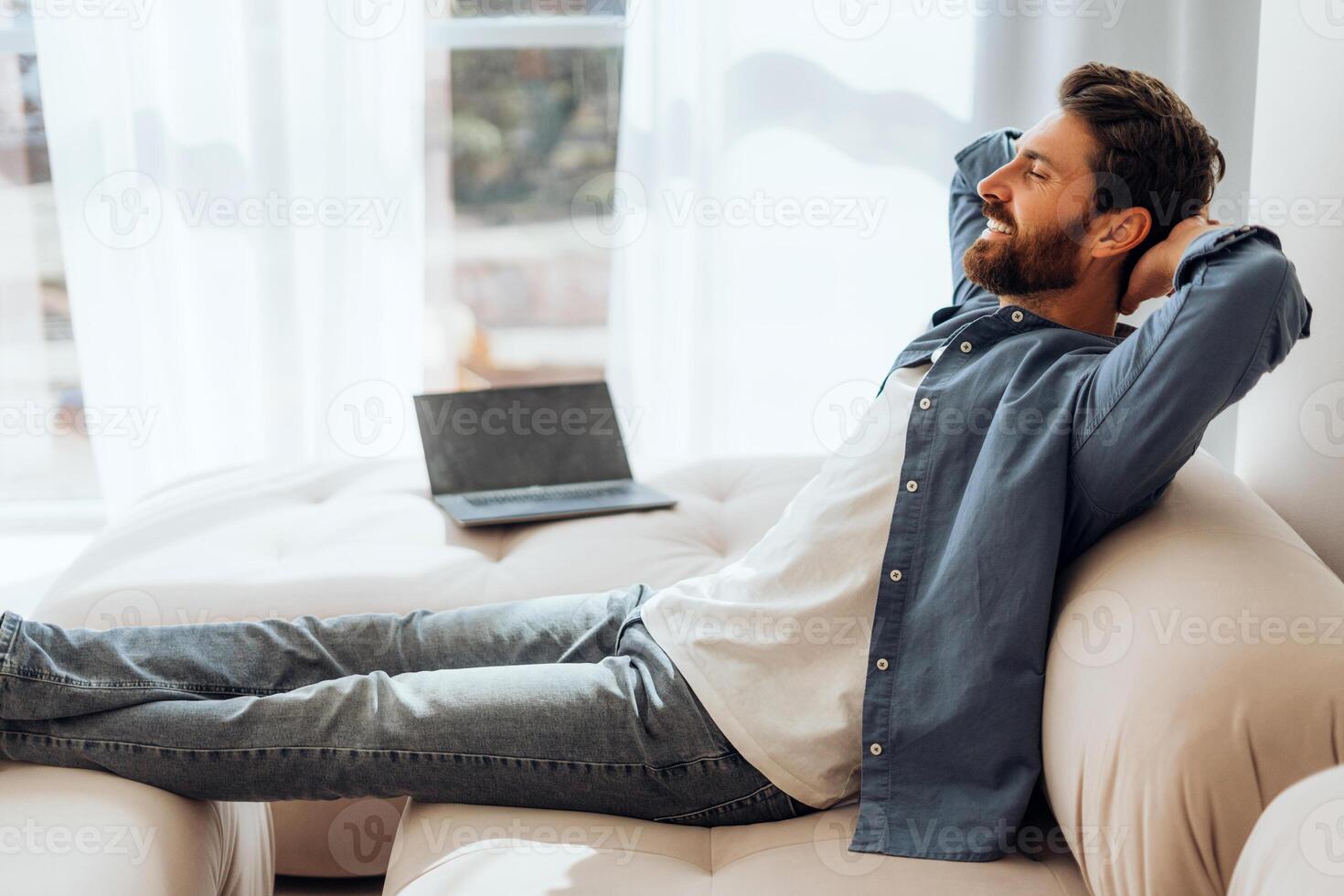 Positive, happy Hispanic woman lying on comfortable sofa at home, relaxing after work at home photo