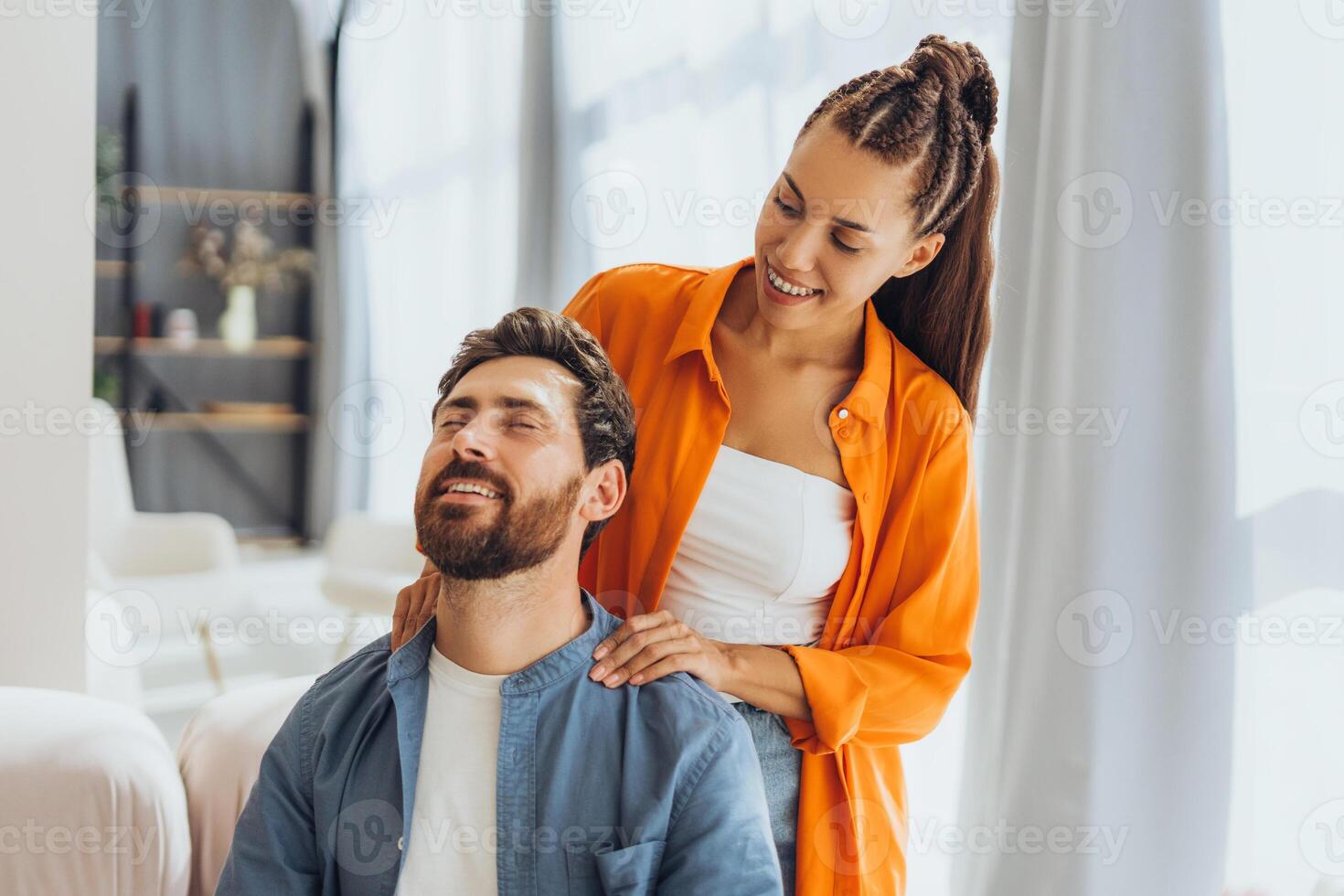Portrait of smiling happy friends, young beautiful woman, making neck massage to bearded man photo