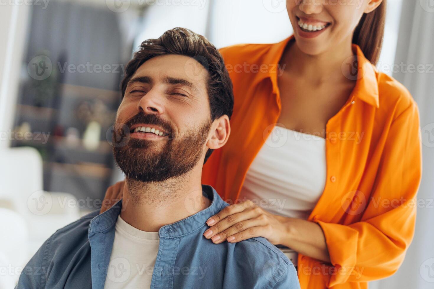 Beautiful, happy couple, attractive Latin woman making shoulder massage to handsome adult man photo