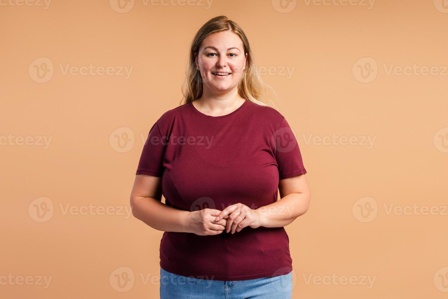 Positive beautiful plus size woman looking at camera in studio photo