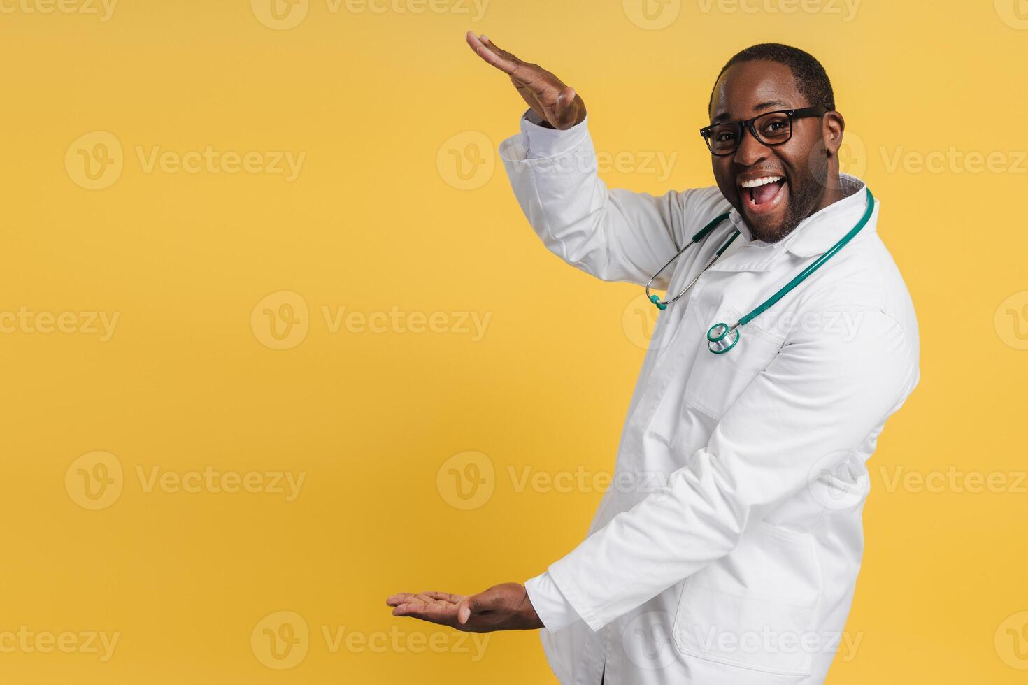 Happy African American doctor pointing at empty space by hands looking at camera photo