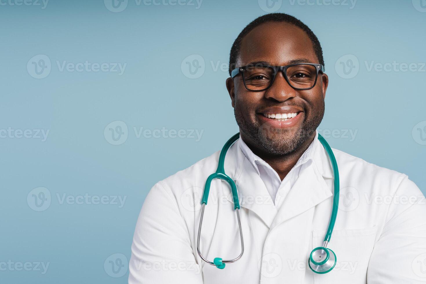 Confident African American doctor smiling and posing over blue studio background photo