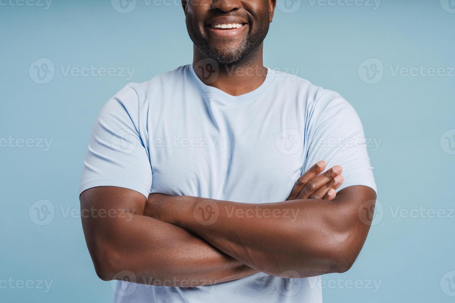Close up of smiling African American man posing with folded hands in studio photo