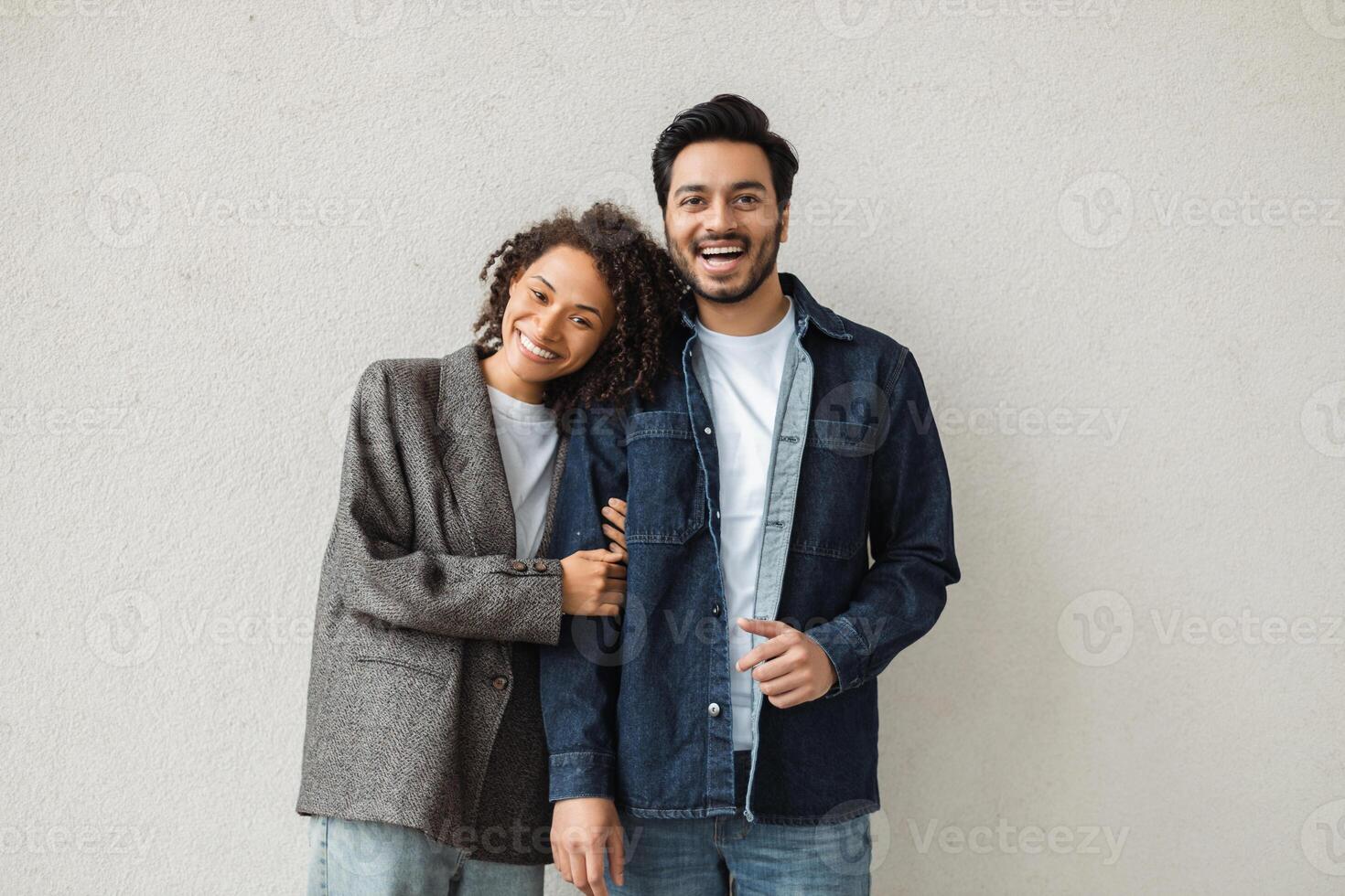 Happy multiracial couple smiling and embracing on white background photo