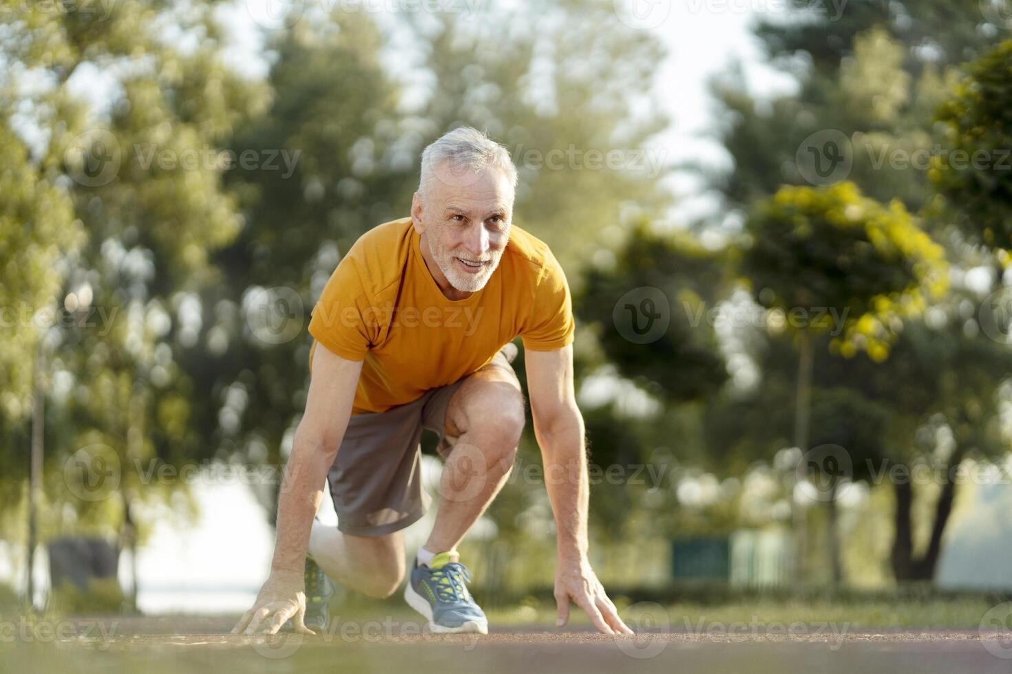 Senior man preparing for a run in a park, embracing fitness and active lifestyle photo