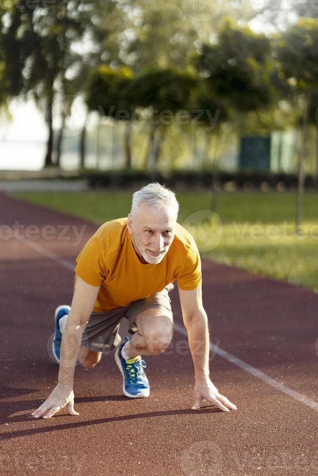 Senior man preparing for a run on the track photo