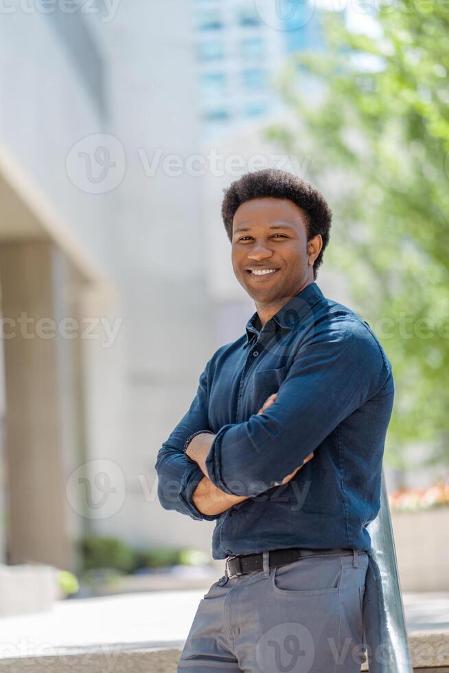 Young professional smiling with arms crossed in the city photo