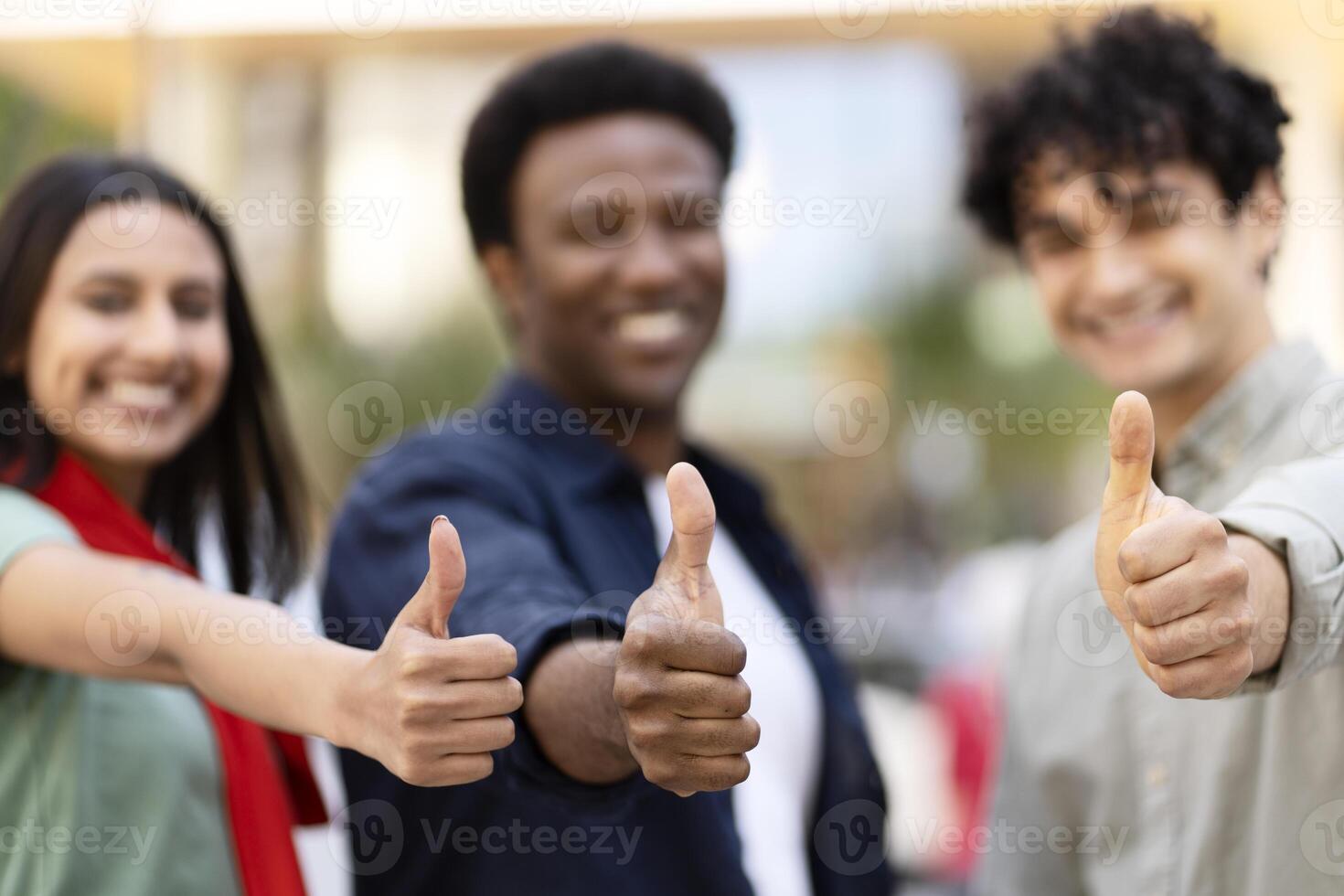 Diverse young people showing thumbs up gesture photo