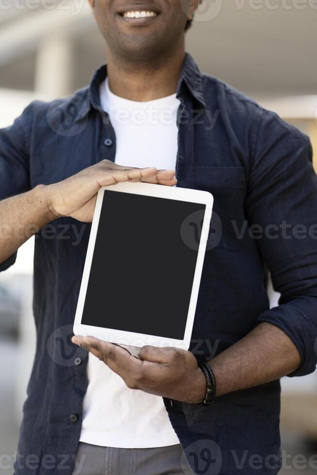 Man smiling and showing digital tablet with empty screen photo