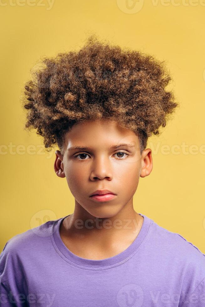 Portrait of serious, pensive African American boy with curly hair looking at camera photo