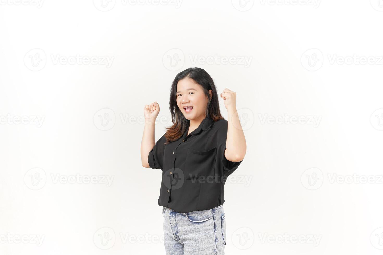 beautiful Asian woman displays a joyful expression, raising her hand in a celebratory gesture against a white background photo
