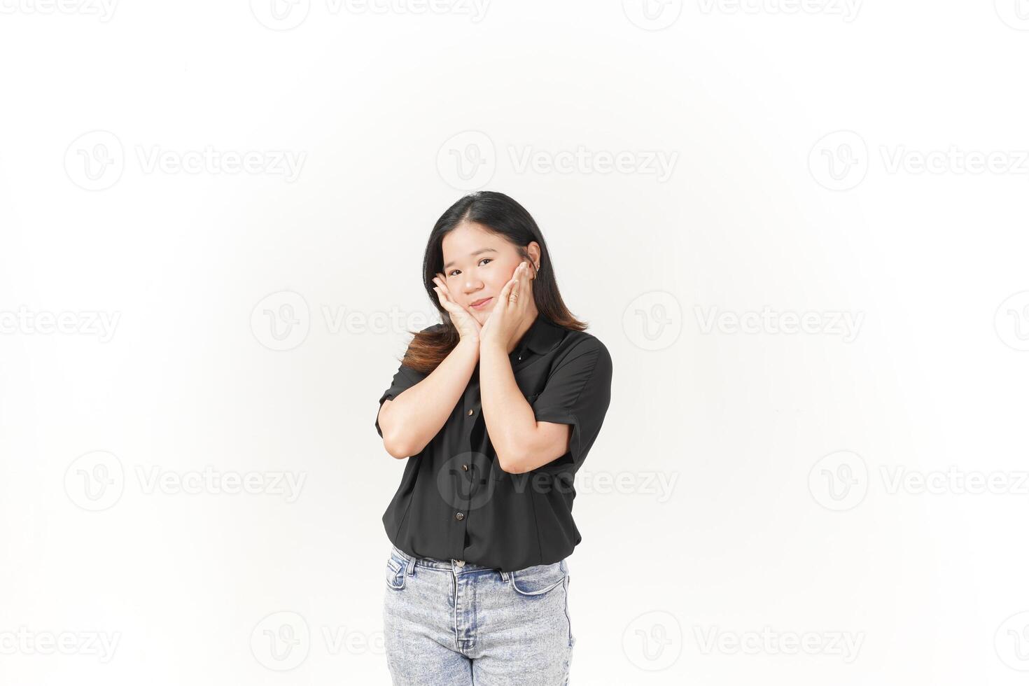 beautiful Asian woman gently holds her cheeks with both palms, showcasing a soft expression against a white background photo