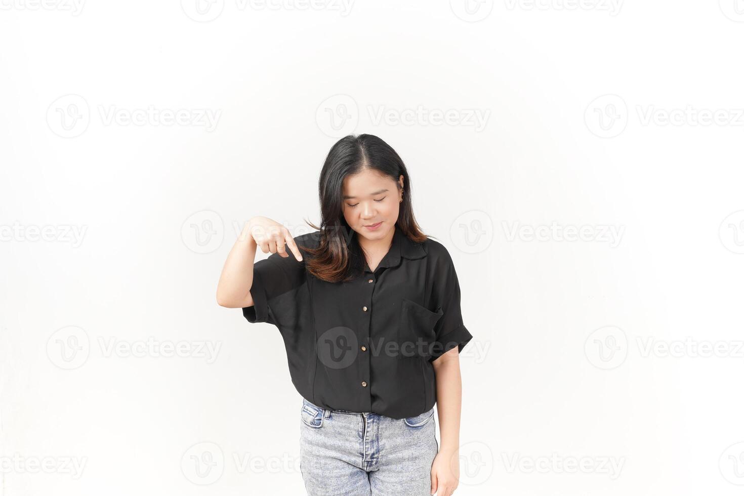 beautiful Asian woman smiles brightly while pointing downward, set against a clean white background photo