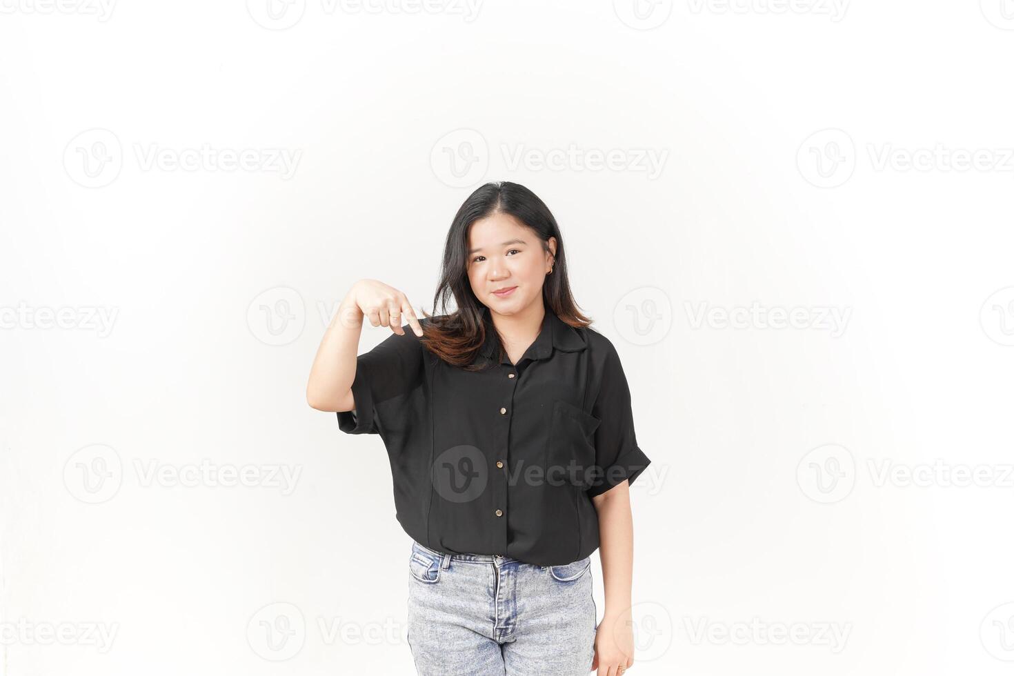 beautiful Asian woman smiles brightly while pointing downward, set against a clean white background photo
