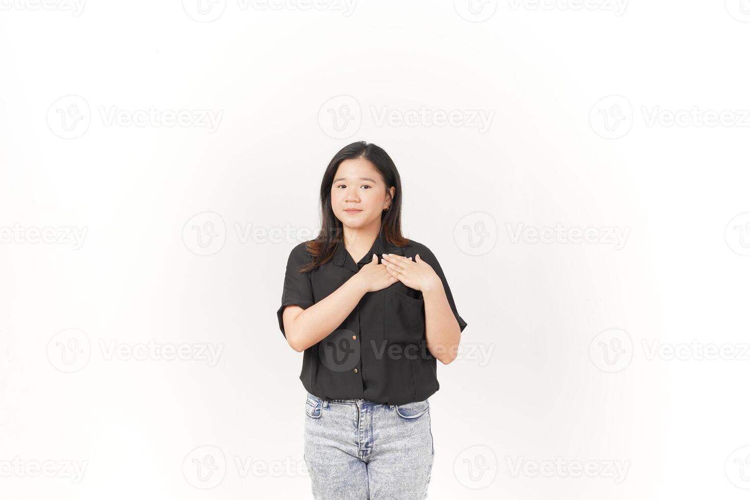 hermosa asiático mujer lugares su mano suavemente en su pecho, expresando sinceridad o gratitud, en contra un blanco antecedentes foto