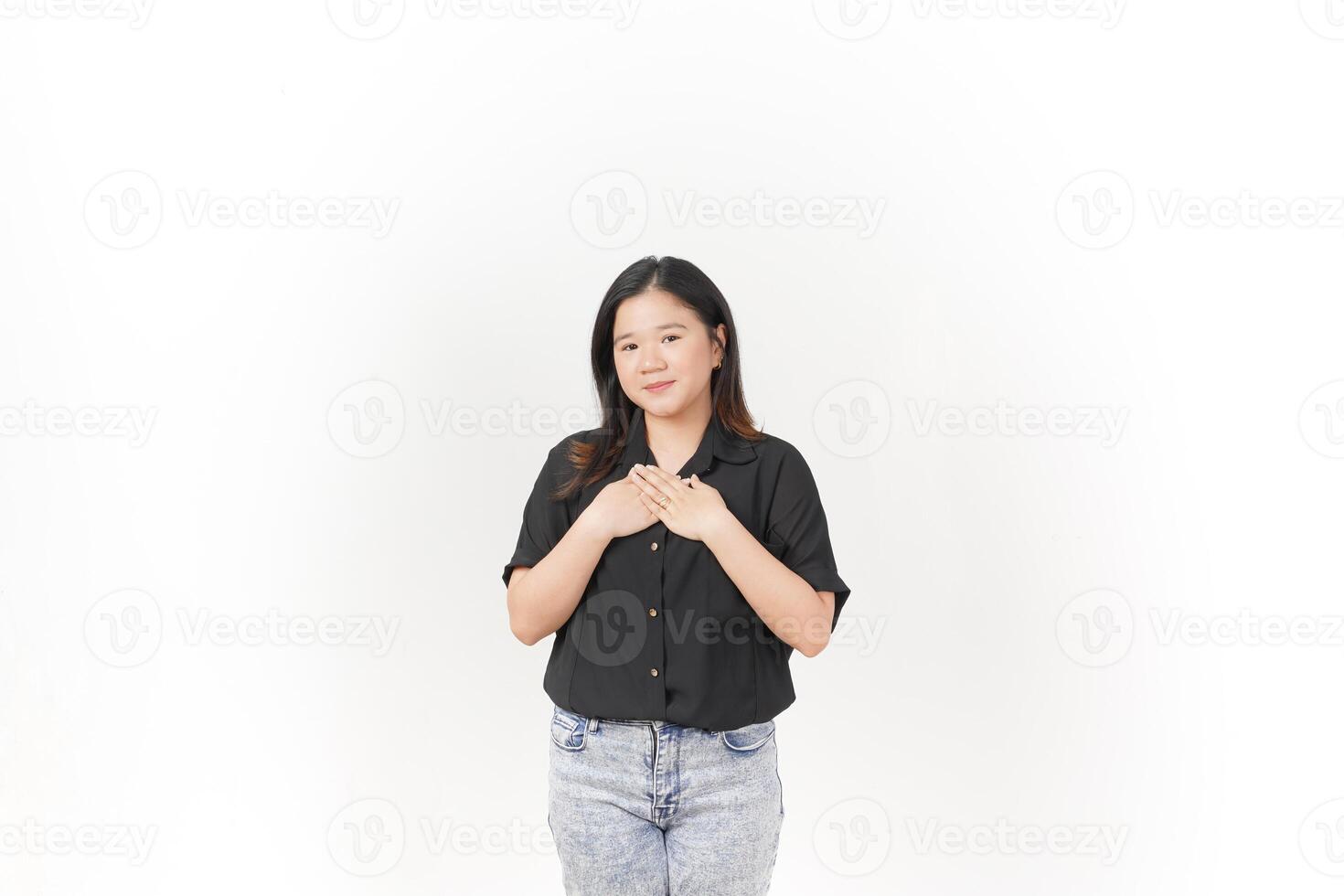 beautiful Asian woman places her hand gently on her chest, expressing sincerity or gratitude, against a white background photo