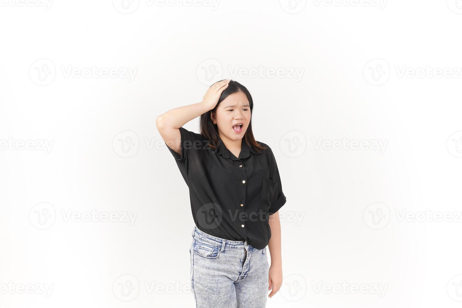 beautiful Asian woman holds her head in pain, with a pained expression showing signs of a headache against a white background photo