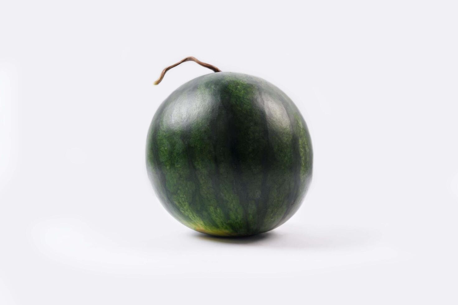 Whole watermelon and seeded slices seen front and top on a white background. Watermelon slices are red, seedy and juicy. photo