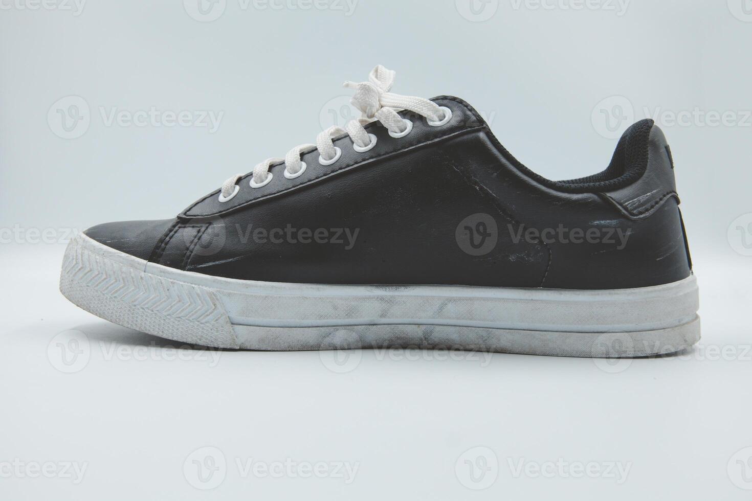 shoe sneaker on white background, close up of sneaker on white background, old black generic sneakers on white background. photo