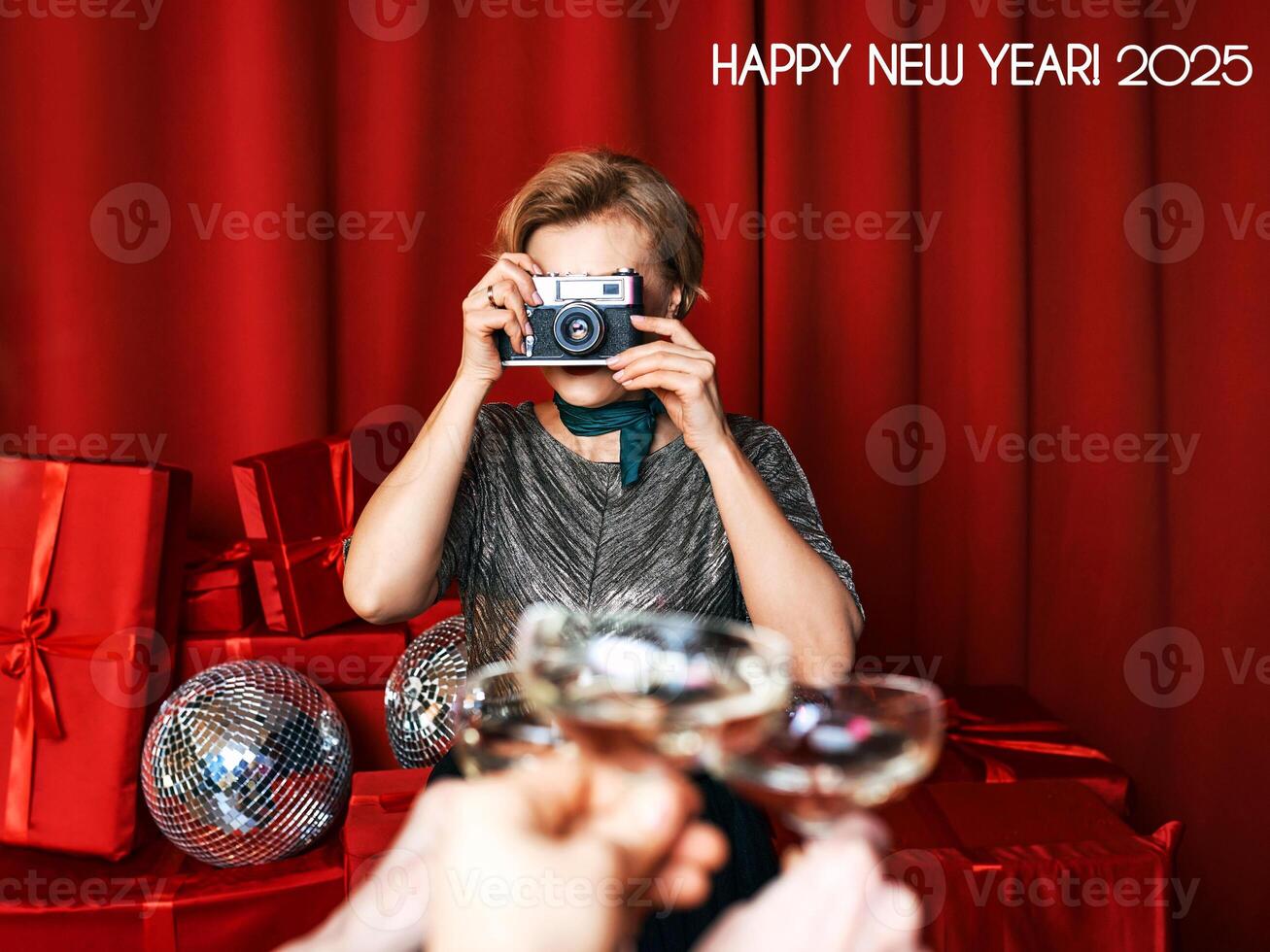 Cheerful beautiful photographer woman at the party celebration on red curtains background. Profession, party concept photo