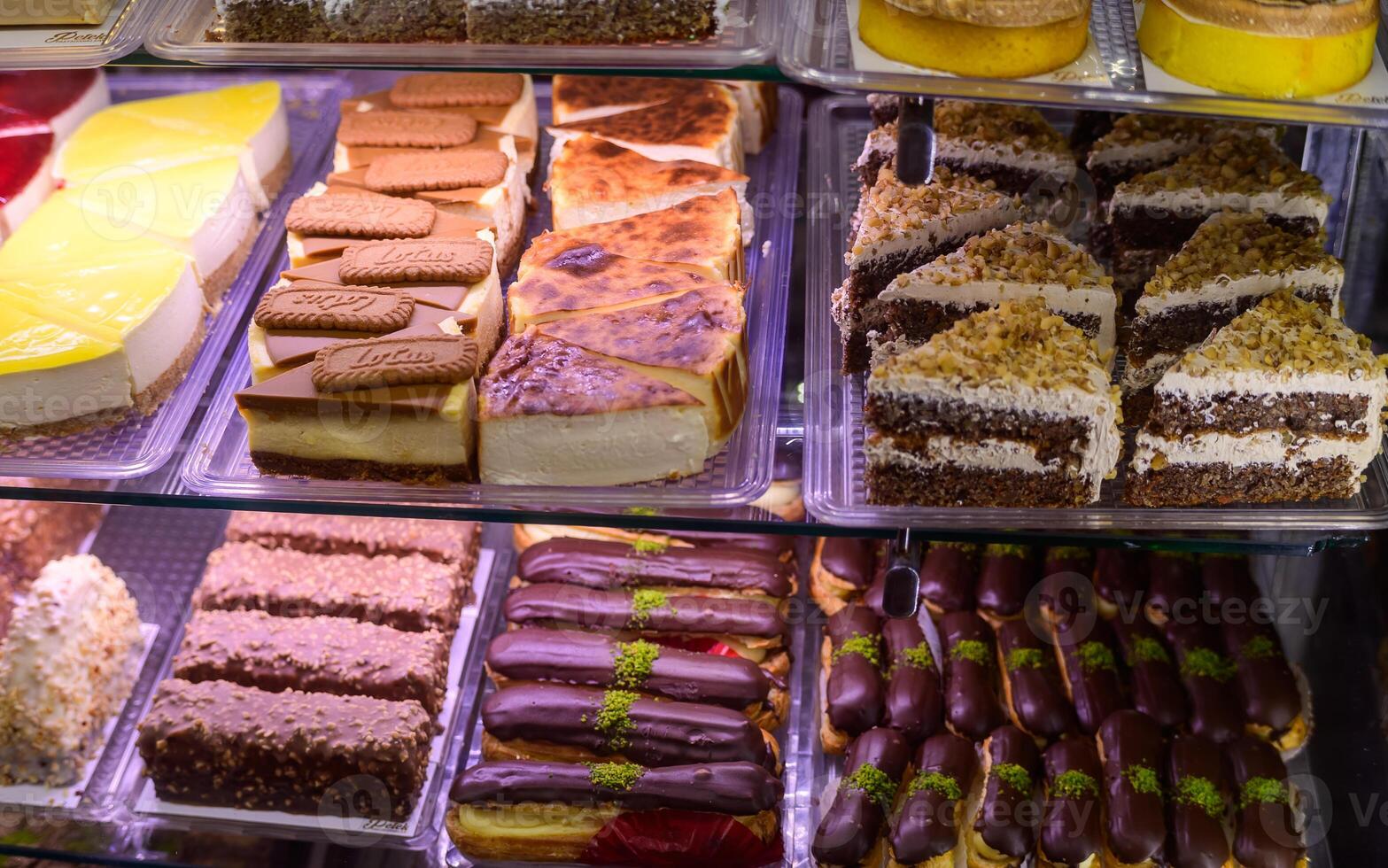 Delectable assortment of pastries displayed in a vibrant bakery case during a busy afternoon photo
