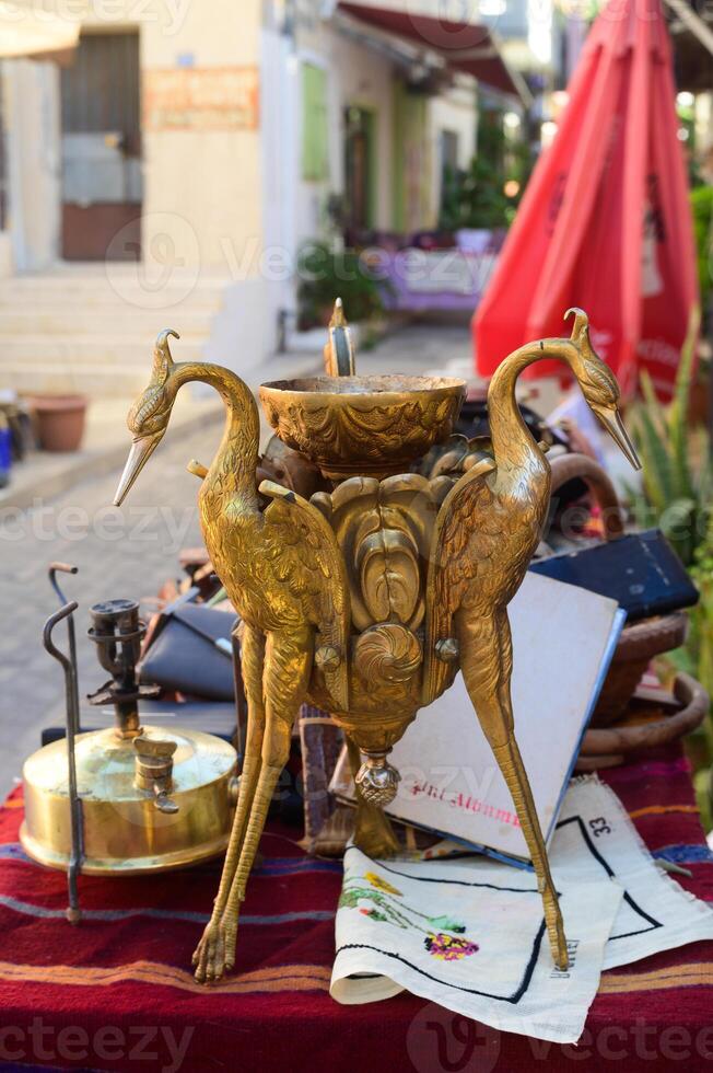 Ornate brass centerpiece featuring cranes, set against vibrant market stalls in a charming bazaar photo