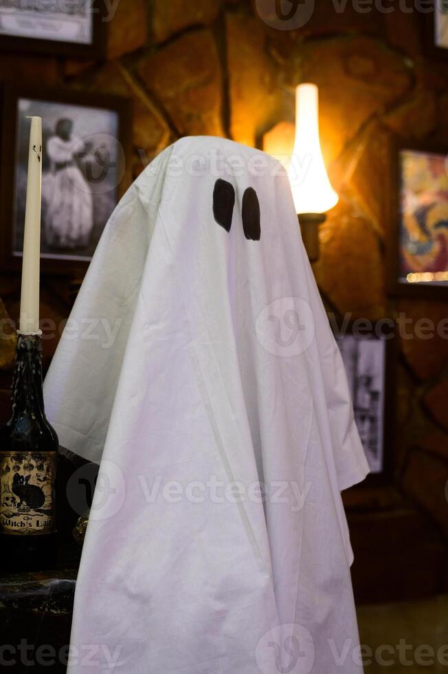 A friendly ghost appears by candlelight in an art-filled room adorned with vintage photographs photo