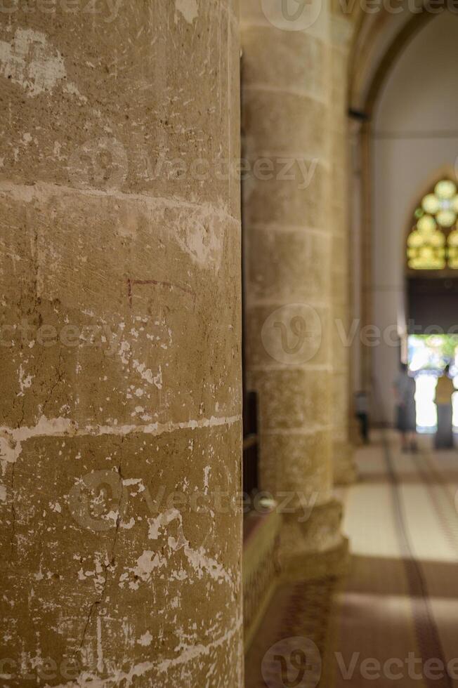 Exploring ancient stone columns inside a historic cathedral on a sunny afternoon photo
