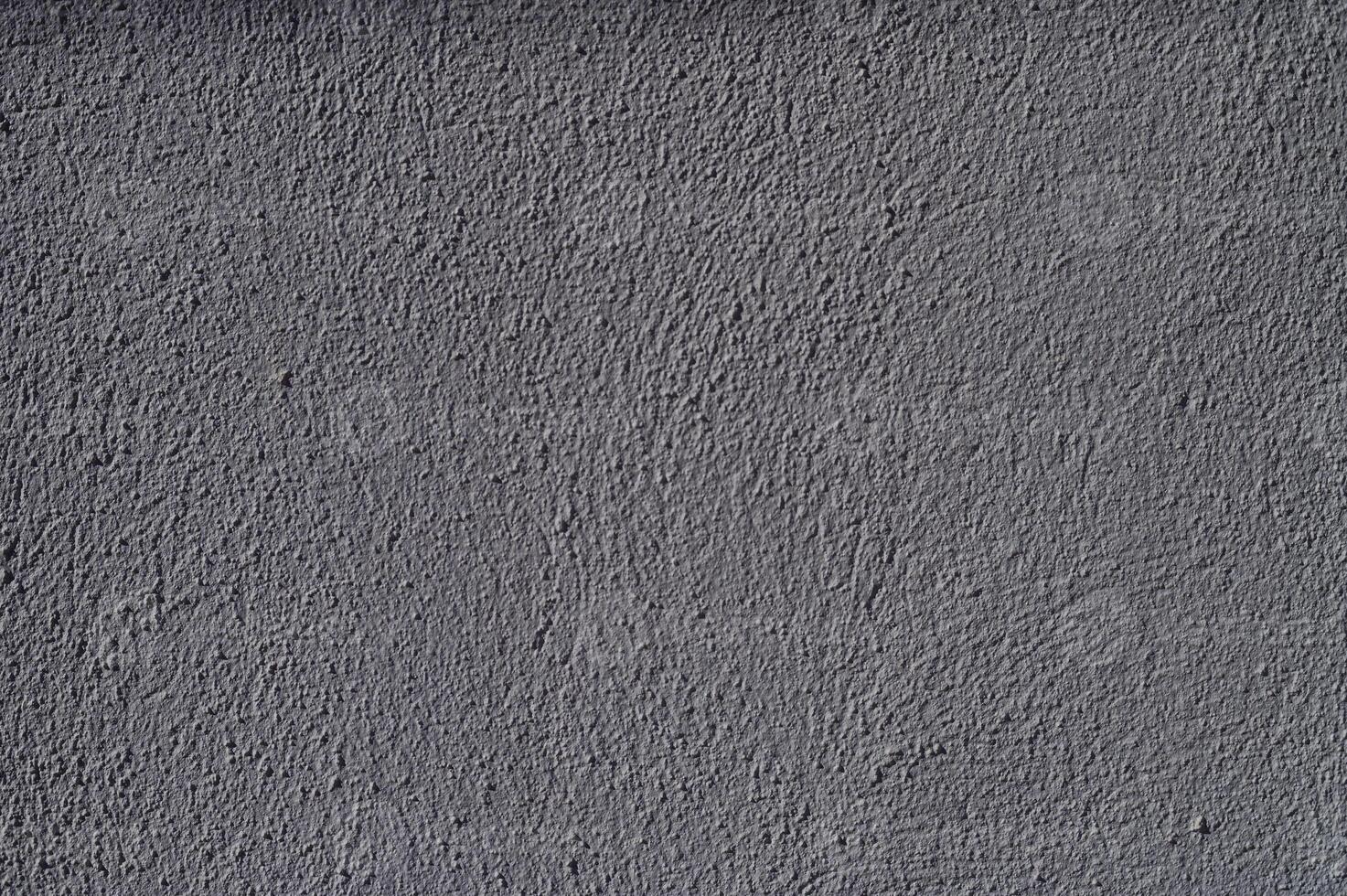 Textured gray wall showcasing subtle variations in color and shadow during the late afternoon light photo