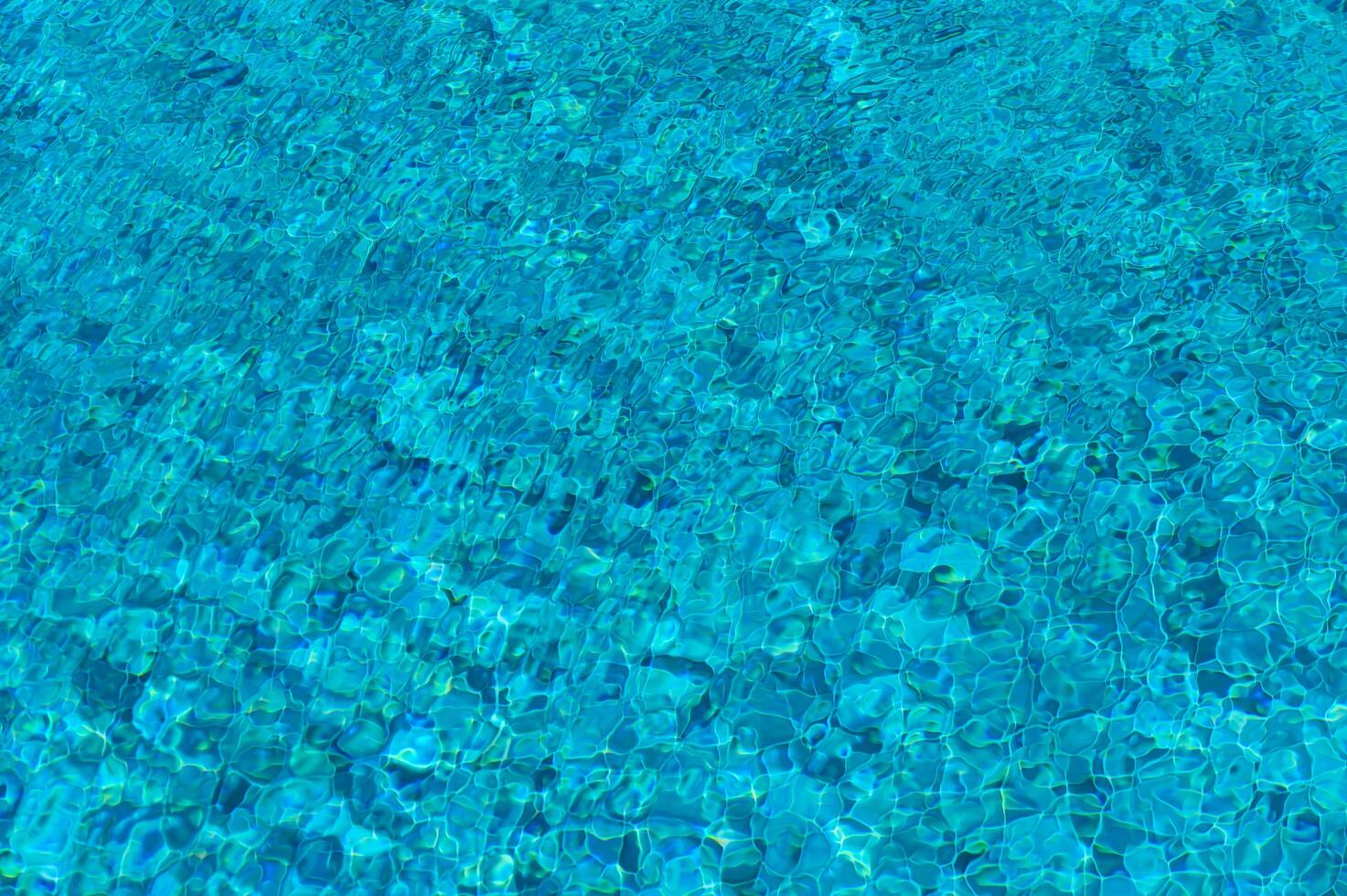 Luminous Turquoise Water Shimmering Under the Sun in a Tranquil Pool Oasis Amidst Vibrant Greenery on a Warm Summer Afternoon photo
