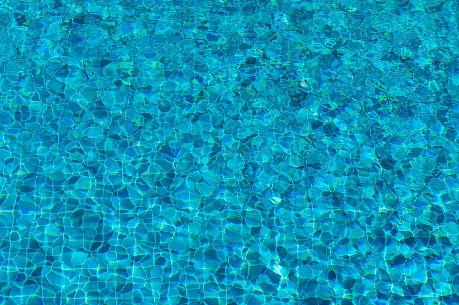 The Shimmering Turquoise Ripples Dance in the Sunlight Above a Tranquil Swimming Pool on a Bright Summer Afternoon photo