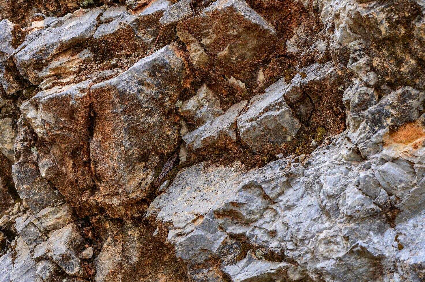 Natural rock formation with layers of gray and brown minerals at a geological site during daylight hours photo