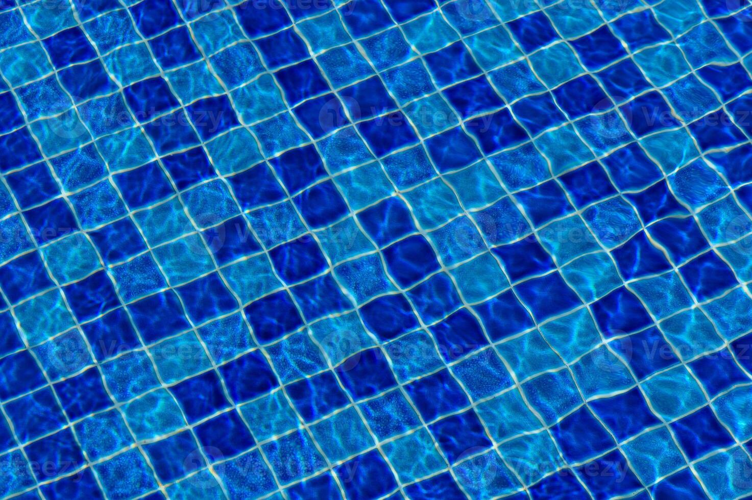 Rippling azure water reflecting sunlight over a tiled pool during a summer afternoon photo