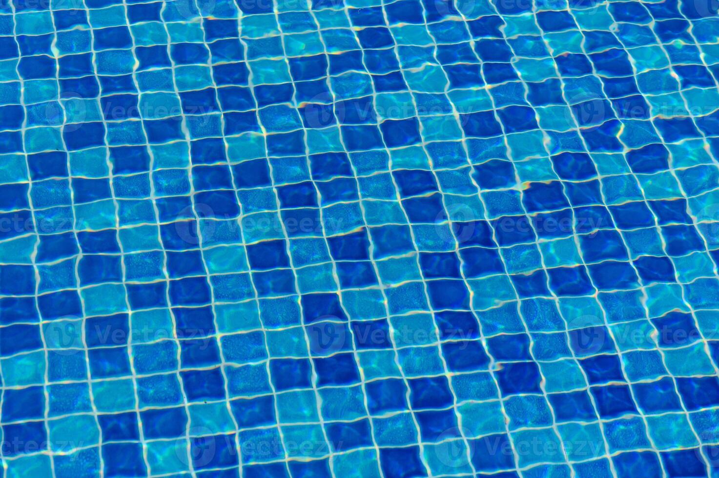 The Shimmering Blue Tiles of a Tranquil Swimming Pool Reflect Sunlight on a Warm Summer Afternoon, Inviting Relaxation and Joy photo