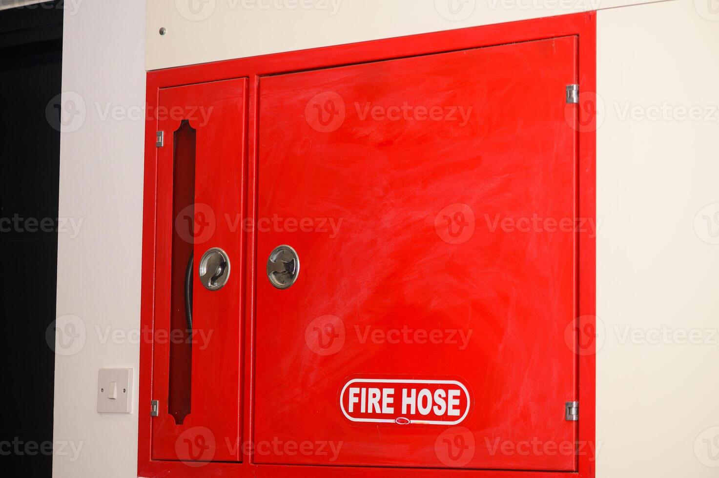 Red fire shield with fire extinguisher in a business center. photo