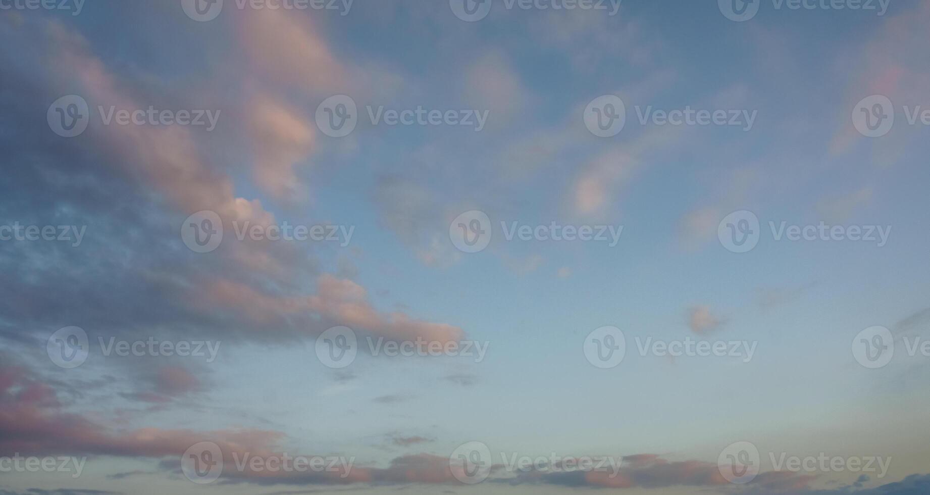 A breathtaking sunset sky painted with soft pink and blue hues, creating a serene twilight atmosphere over the landscape photo