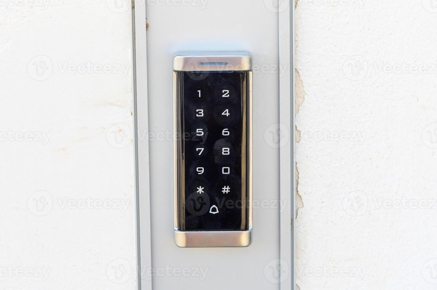 Modern Electronic Keypad for Secure Access Displayed on a White Wall at a Residential Entrance in Bright Daylight photo