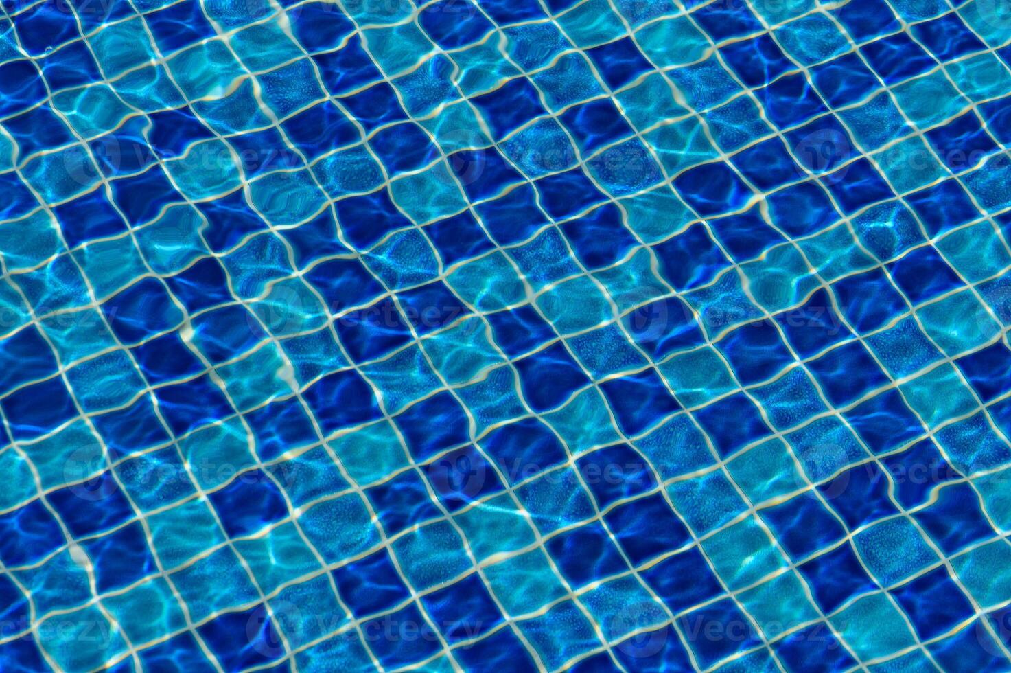 Rippling water patterns create a mesmerizing blue mosaic in a sunlit swimming pool photo