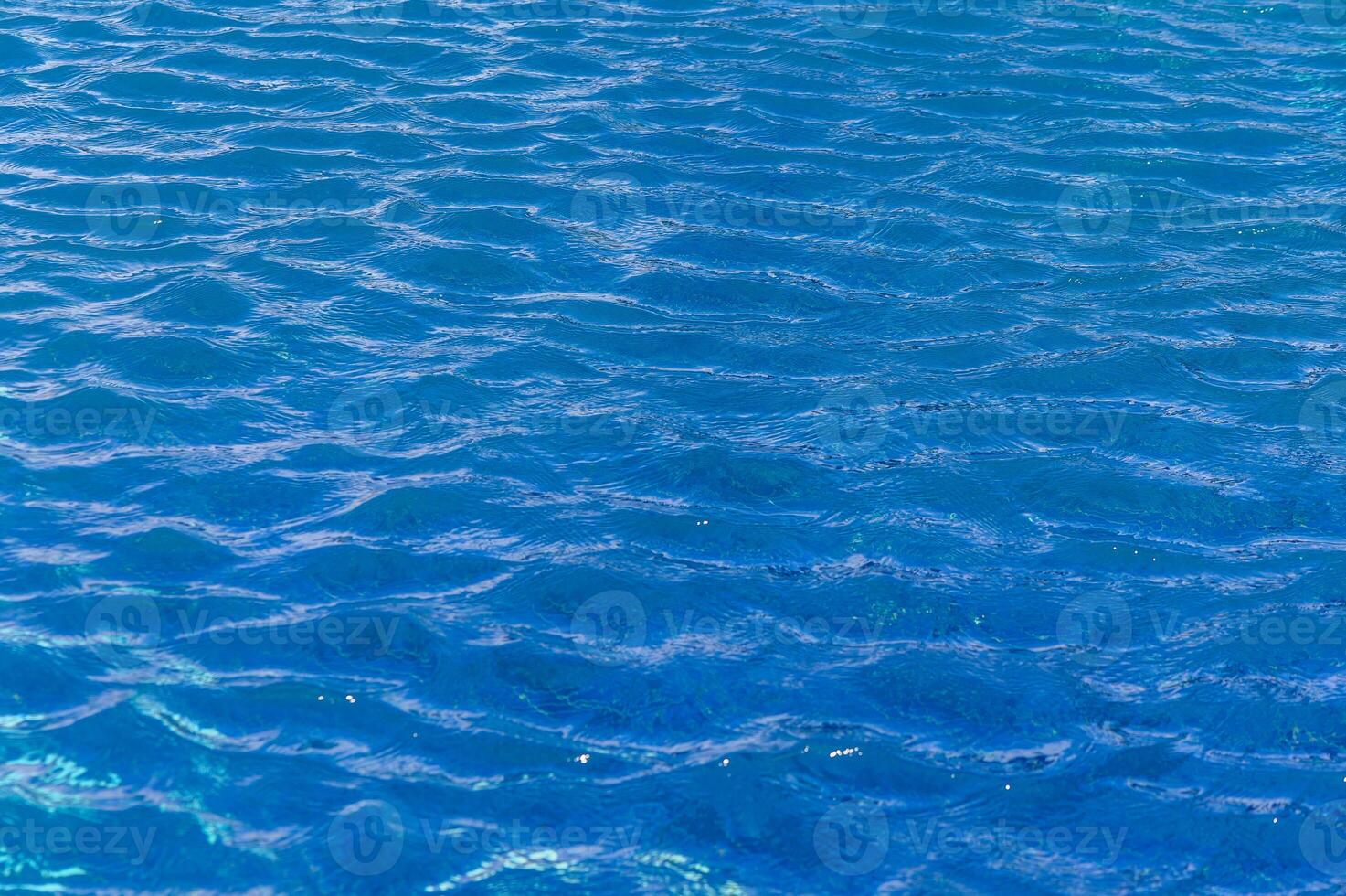 Rippling azure waters reflecting sunlight on a tranquil summer afternoon by the beach photo
