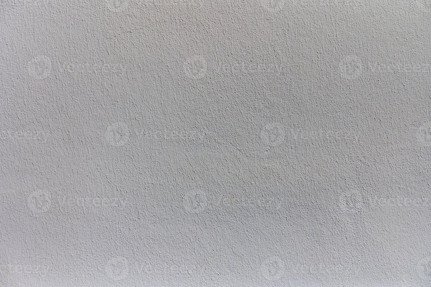 An abstract view of a textured gray wall showcasing subtle variations in color and tone under soft natural light photo